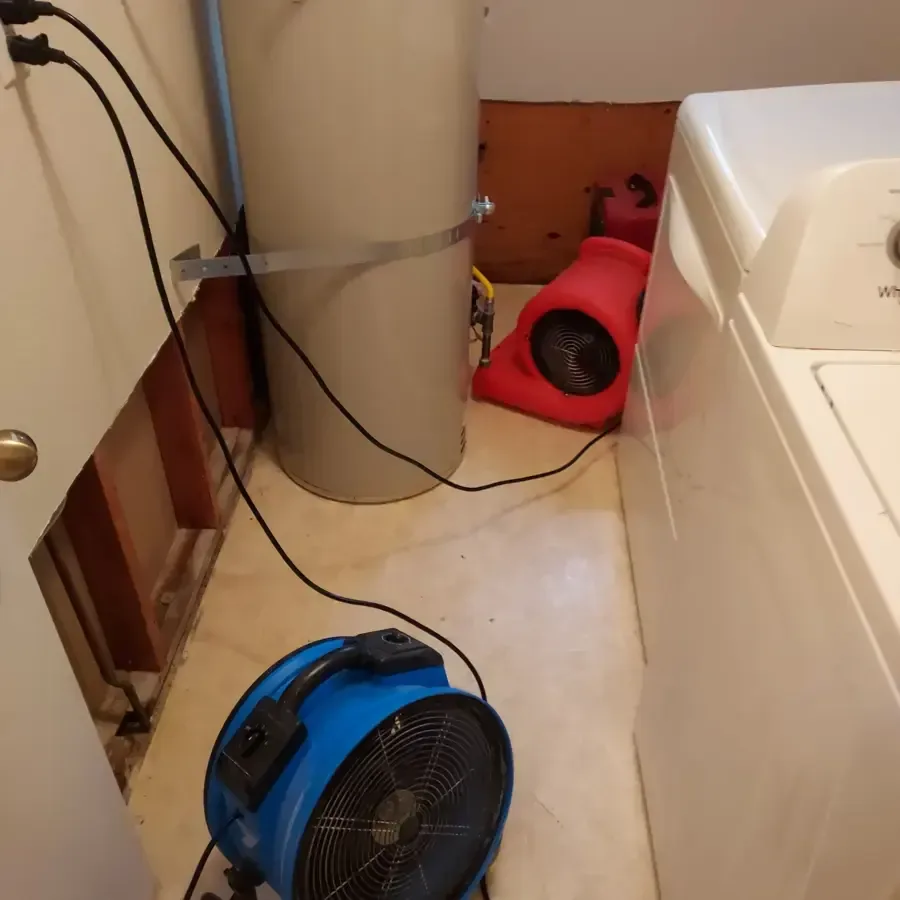 Air movers beside an opened bathroom wall and bathtub